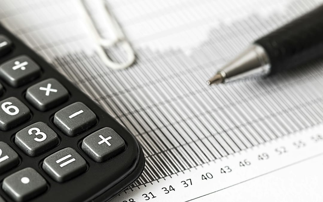 calculator, pen and tax return papers